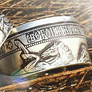 a couple of silver rings sitting on top of a pile of wood