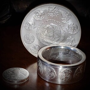 a couple of silver rings sitting on top of a wooden table