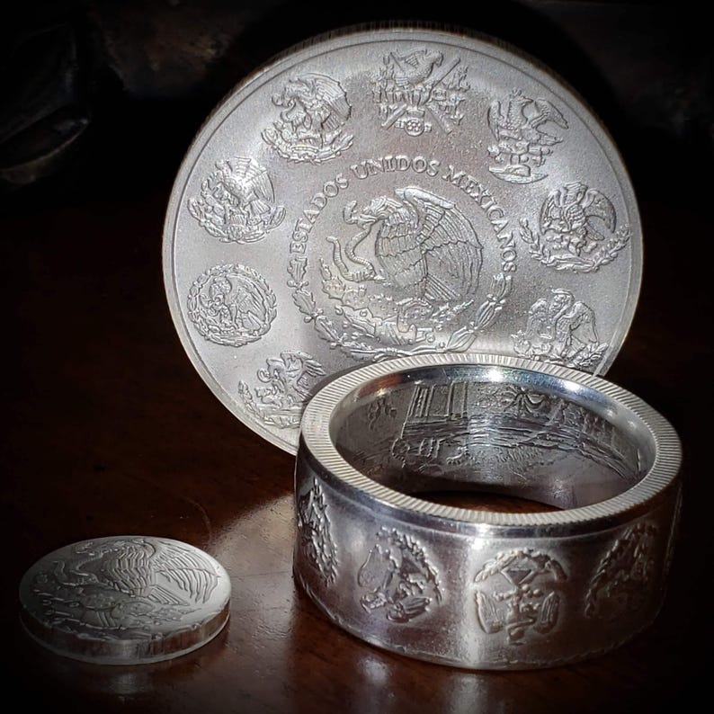 a couple of silver rings sitting on top of a wooden table