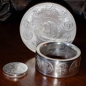 a couple of silver rings sitting on top of a wooden table