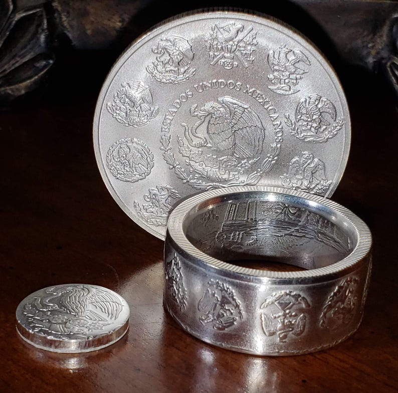 a couple of silver rings sitting on top of a wooden table