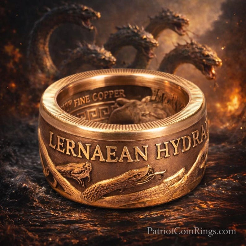 a large, ornate gold ring with the inscription "Lernaean Hydra" on it, surrounded by a fiery background with multiple snakes.