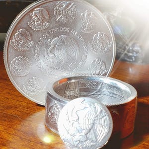 a couple of silver coins sitting on top of a wooden table