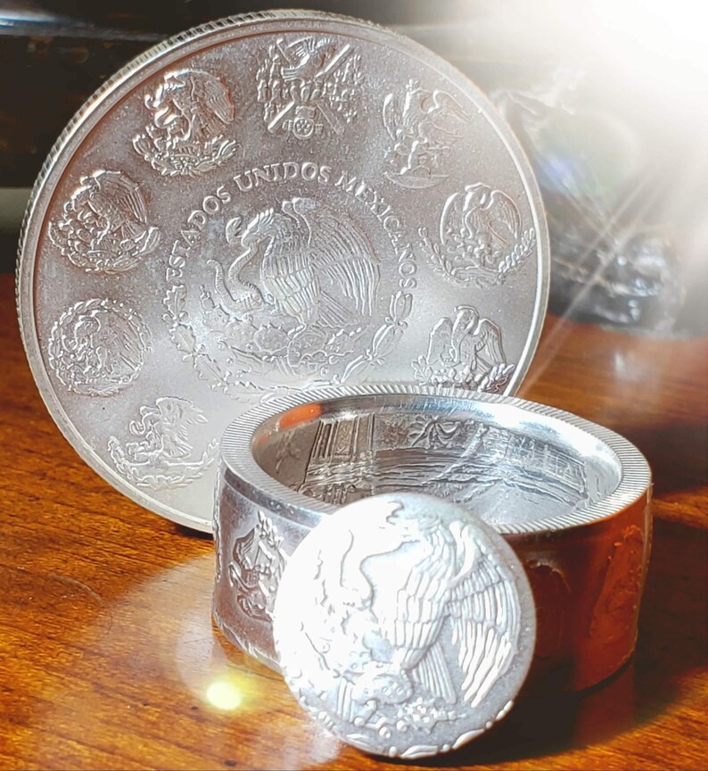 a couple of silver coins sitting on top of a wooden table