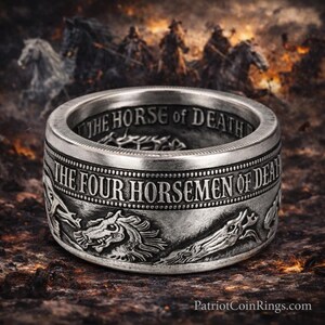 A silver ring with a detailed design featuring horses and the text "THE HORSE OF DEATH" engraved on it.