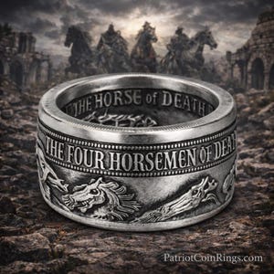 a silver ring with a detailed design, including a horse and a dragon, set against a dark, rocky background with a castle-like structure in the distance.