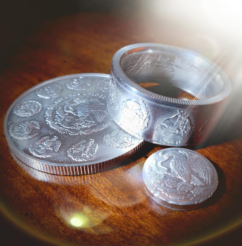 two silver coins sitting on top of a wooden table