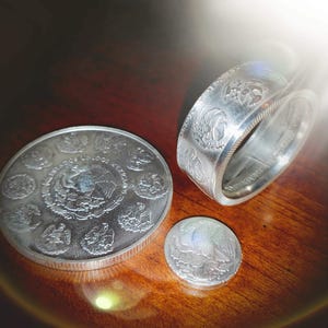 a couple of silver coins sitting on top of a wooden table