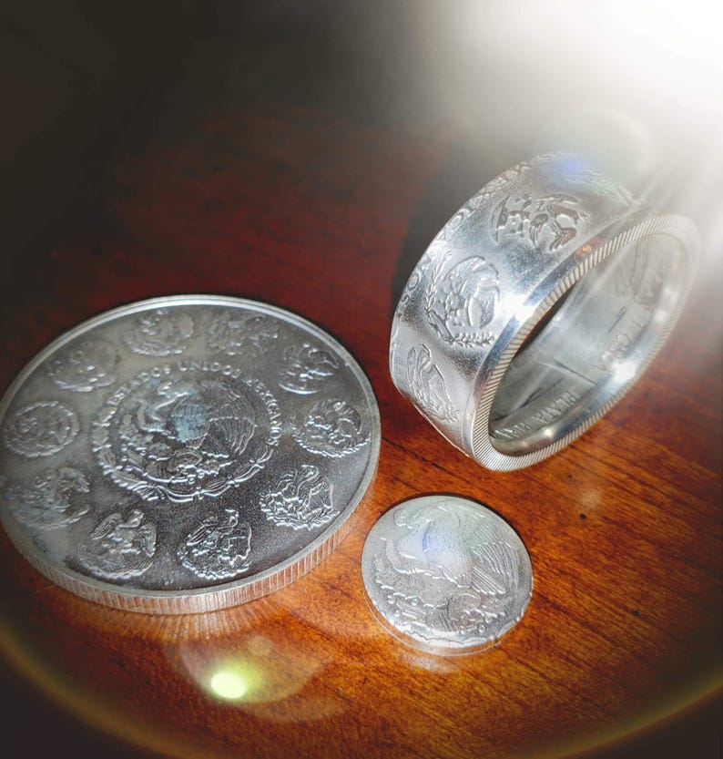 a couple of silver coins sitting on top of a wooden table