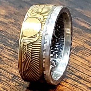 a gold and silver ring on a wooden surface