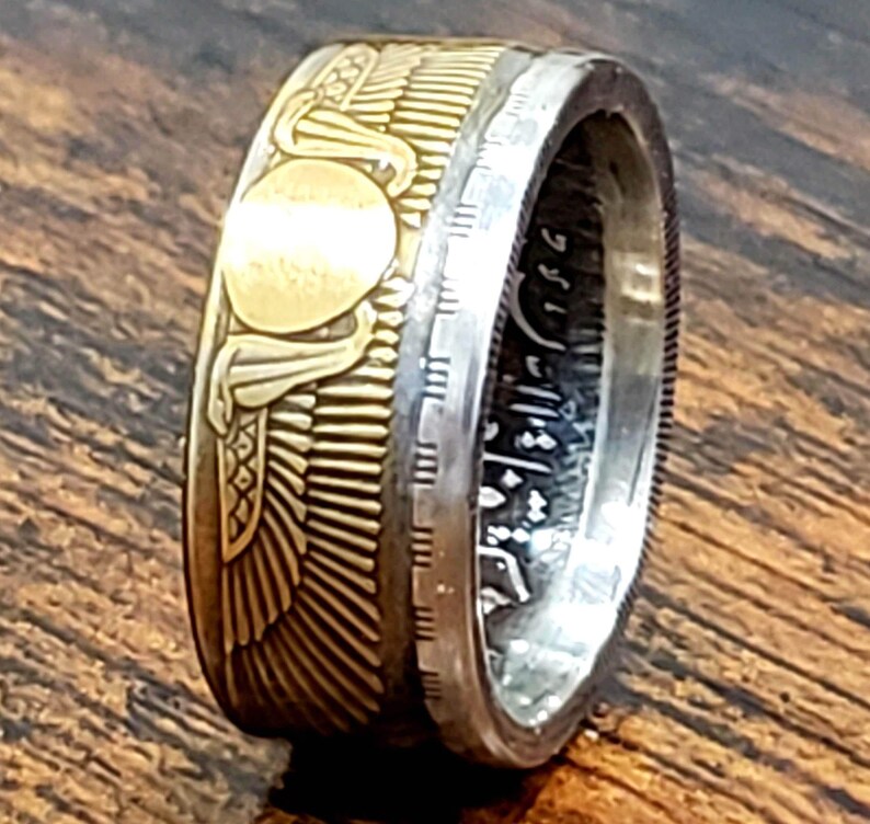 a gold and silver ring on a wooden surface