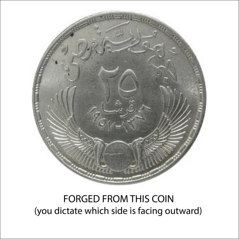 A coin with a winged design and Arabic script, indicating it is a coin that has been forged from it.