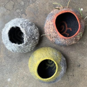 3 felted vessels symbolizing nordic landscapes. They are raw on the outside, the wool picturing both plants, rocks and snow. On the inside ancient traces of human activity - petroglyphs that show  human communication over time.