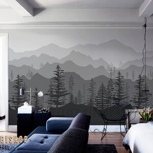 May include: A black and white mountain range wall decal with a silhouette of trees in the foreground. The decal is applied to a wall in a living room setting.