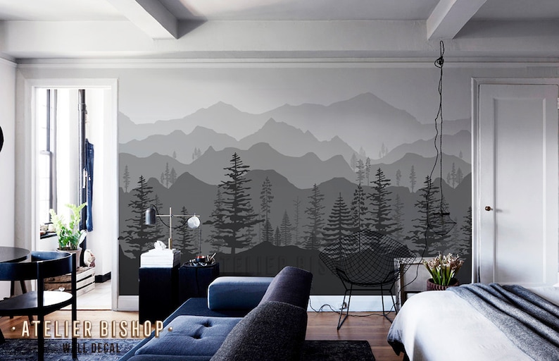 May include: A black and white mountain range wall decal with a silhouette of trees in the foreground. The decal is applied to a wall in a living room setting.
