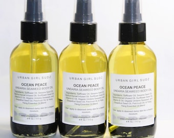 May include: Three amber glass bottles with black spray tops and labels. The labels read "Urban Girl Sudz", "Ocean Peace", "Undaria Seaweed Body Oil", and list ingredients. Each bottle contains 4 oz (113 g) of oil.