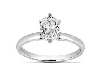 May include: A silver solitaire engagement ring with an oval-shaped diamond.