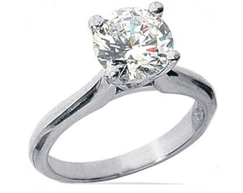 May include: A silver engagement ring with a large, round, clear diamond.