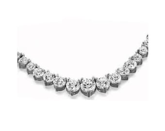 May include: A diamond necklace with a row of pear-shaped diamonds set in a silver metal setting.