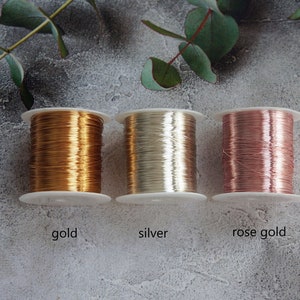 Puede incluir: Tres carretes de alambre, uno dorado, uno plateado y uno de oro rosa. Los carretes est&aacute;n etiquetados como "gold", "silver" y "rose gold".