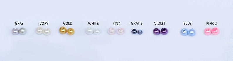 Puede incluir: Diez pares de cuentas de perlas redondas en diferentes colores, incluyendo gris, marfil, dorado, blanco, rosa, azul y violeta.