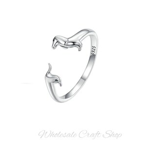 Peut inclure: Une bague en argent avec un motif de teckel. La bague est ouverte et le teckel fait face au porteur. La bague est marqu&eacute;e "S925" sur le c&ocirc;t&eacute;.