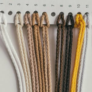 Puede incluir: Una carta de colores de 10 colores diferentes de cordón, que van del blanco al amarillo. Los cordones están dispuestos en una fila, con cada cordón etiquetado con un número del 1 al 10.