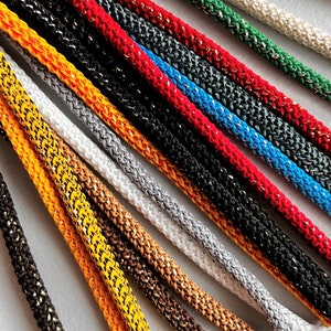 May include: A collection of colorful cords with a metallic sheen. The cords are arranged in a fan shape, with the ends of the cords pointing towards the bottom of the image.