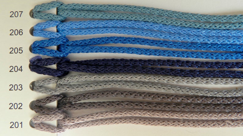May include: A color chart displaying braided cords in various shades of blue, gray, and brown. The cords are labeled with numbers from 201 to 207, showcasing a range of hues from light blue to dark gray. The texture of the cords is clearly visible.