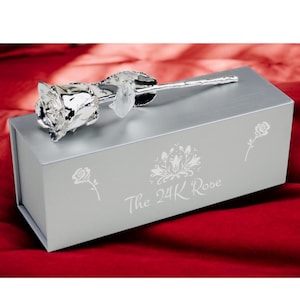 May include: A silver rose in a silver box with the words "The 24K Rose" engraved on the box.