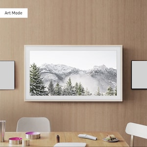 May include: A white framed television displaying a snowy mountain scene with the text "Art Mode" in the top left corner.