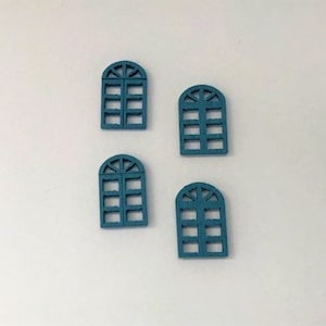 Puede incluir: Cuatro marcos de ventanas de madera azul con parte superior arqueada y múltiples paneles. Los marcos están dispuestos en un patrón rectangular sobre un fondo blanco.