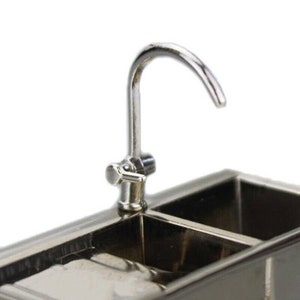 May include: A silver double sink with a chrome faucet. The faucet has a single handle and a curved spout.