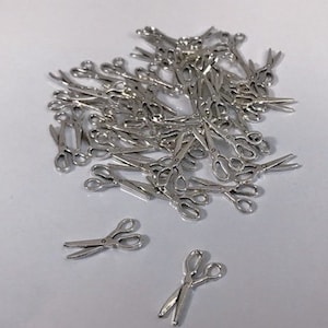 May include: A pile of miniature silver-coloured scissors. The scissors are arranged in a random pattern, with some overlapping. The scissors are all the same size and shape.