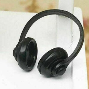 May include: Black plastic headphones with a headband and earcups. The earcups have a textured design.