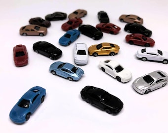 May include: A collection of miniature toy cars in various colors, including red, black, blue, white, and gold. The cars are arranged on a white surface, showcasing their different designs and styles. The image captures a diverse range of toy vehicles.