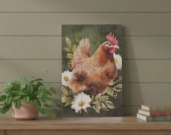 Puede incluir: Una pieza de arte mural rectangular que presenta una ilustración estilo acuarela de una gallina marrón con cresta roja. La gallina está rodeada de flores blancas similares a margaritas y follaje verde sobre un fondo verde oscuro y apagado.