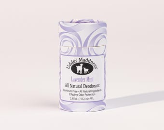 Może przedstawiać: Cylindryczny dezodorant w sztyfcie z lawendowo-białym wzorem w wiry. Etykieta głosi "Udder Maddness Lavender Mint All Natural Deodorant". Produkt jest wolny od aluminium i zawiera naturalne składniki. Waga netto: 75g.