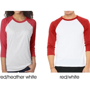 May include: Two baseball t-shirts, one with red sleeves and a heather white body, and the other with red sleeves and a white body.