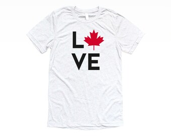 May include: A heather grey t-shirt with a black graphic that says "LOVE" with a red maple leaf in place of the "O".