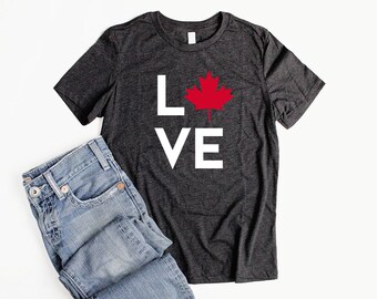 May include: A dark heather grey t-shirt with a white "LOVE" graphic and a red maple leaf in the center.