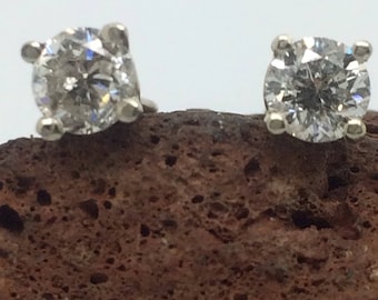 Puede incluir: Un par de pendientes de botón de plata con diamantes redondos, transparentes y brillantes.