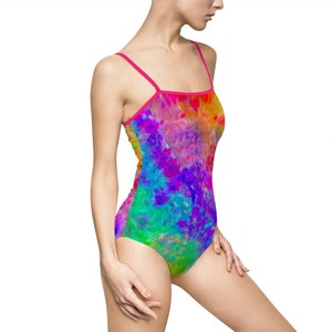 Könnte beinhalten: Ein leuchtender Regenbogen-Batik-Badeanzug mit einem rosafarbenen Träger. Der Badeanzug hat ein farbenfrohes abstraktes Muster.