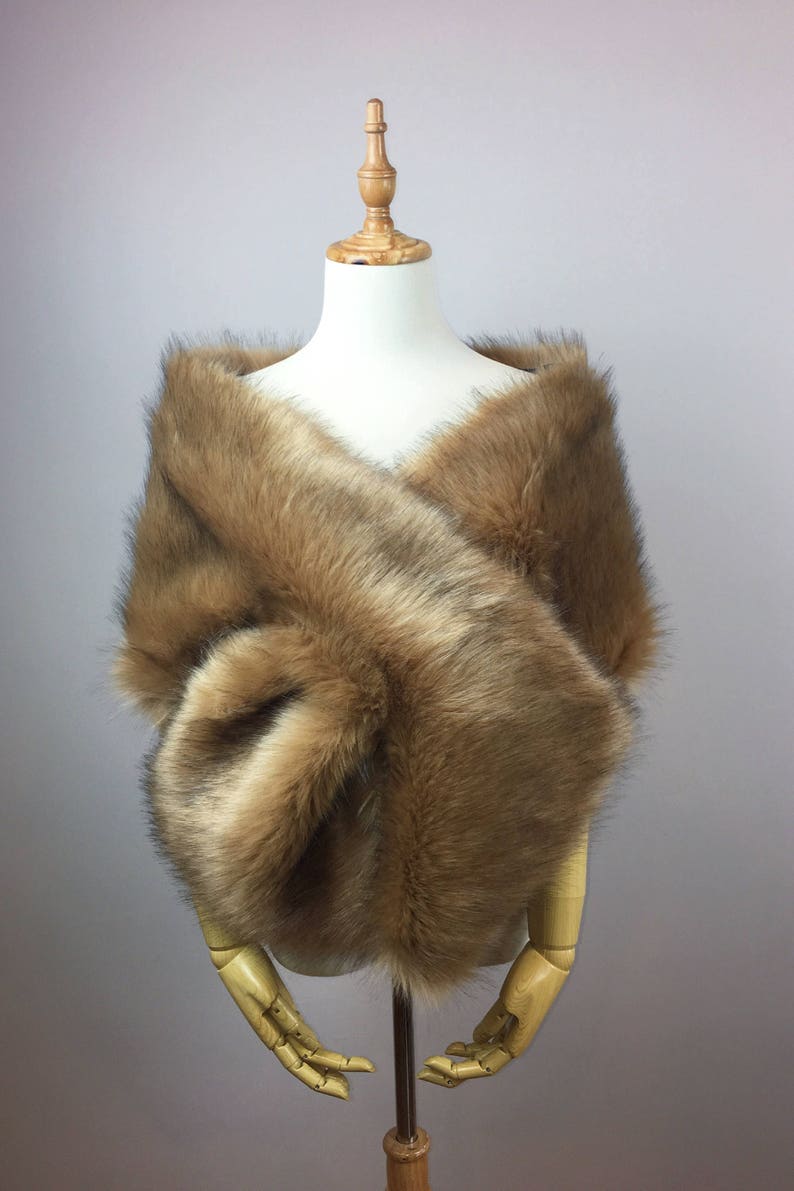 May include: A brown faux fur shawl draped over a mannequin. The shawl is soft and fluffy, and it would be perfect for a wedding or other special occasion.