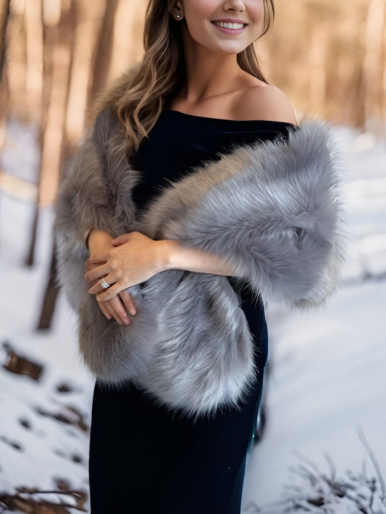 May include: A gray faux fur shawl with a black velvet dress underneath. The shawl is draped over the shoulders and the dress is off-the-shoulder.