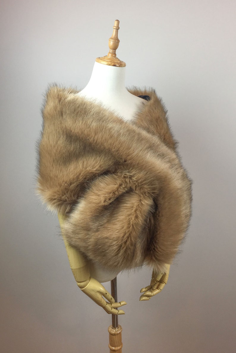 May include: A brown faux fur shawl draped over a mannequin. The shawl is soft and fluffy, and it would be perfect for a special occasion.