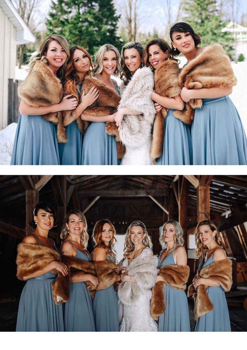 May include: A group of bridesmaids wearing blue dresses and brown faux fur wraps stand in a snowy outdoor setting. The bride is in the center wearing a white dress and a white faux fur wrap.