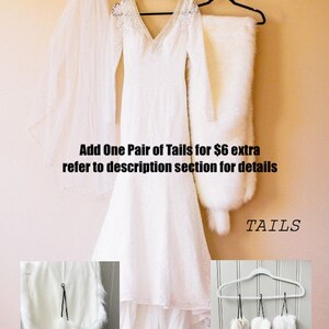 May include: A white wedding dress with lace detailing hangs on a hanger with a white fur shawl and a white veil. The dress has a long train and a fitted bodice. The image also shows a close-up of a white fur tail and a set of five white fur tails hanging on a hanger. The text "Add One Pair of Tails for $6 extra refer to description section for details" and "TAILS" is visible in the image.