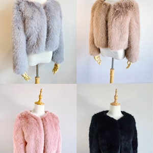 May include: Four faux fur jackets on mannequins. The jackets are in gray, brown, pink, and black.