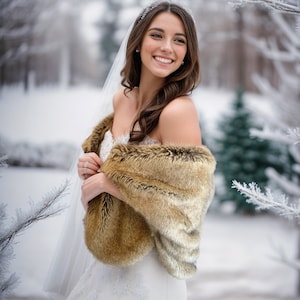May include: A bride wearing a white wedding dress with a faux fur shawl, standing in a snowy winter setting.